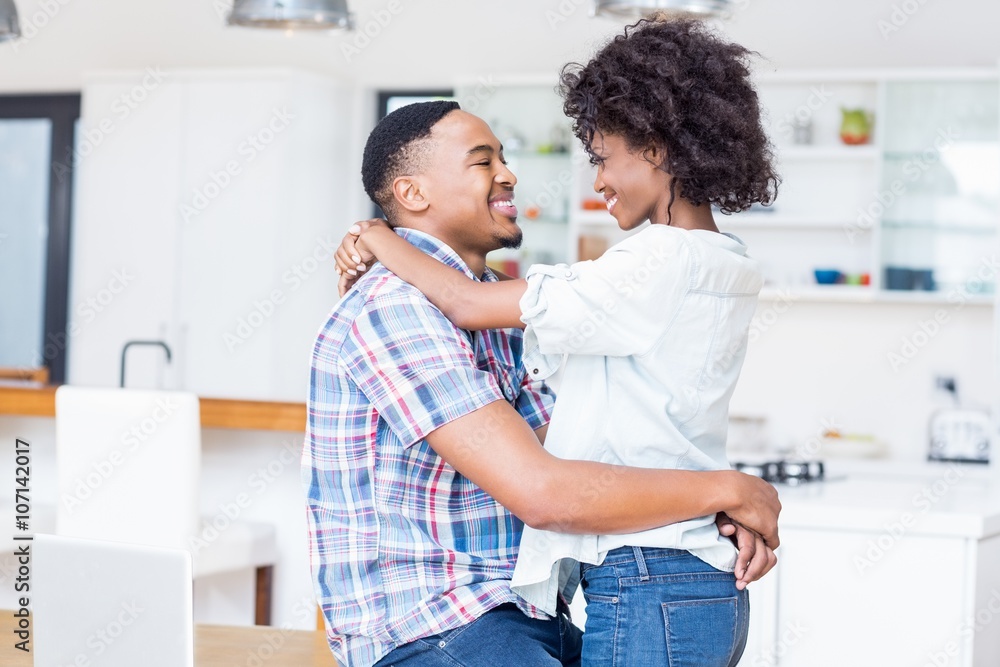 Young couple embracing face to face in kitchen Young couple embracing face to face in kitchen