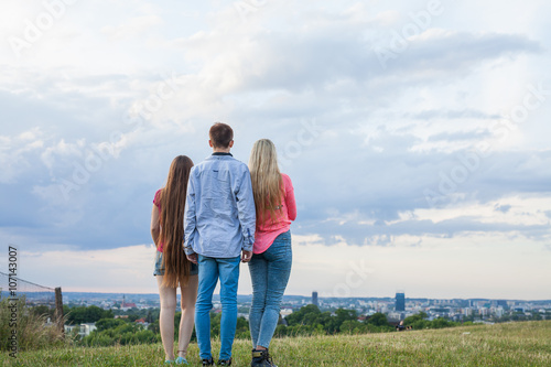 Three friend looking at the city panorama.