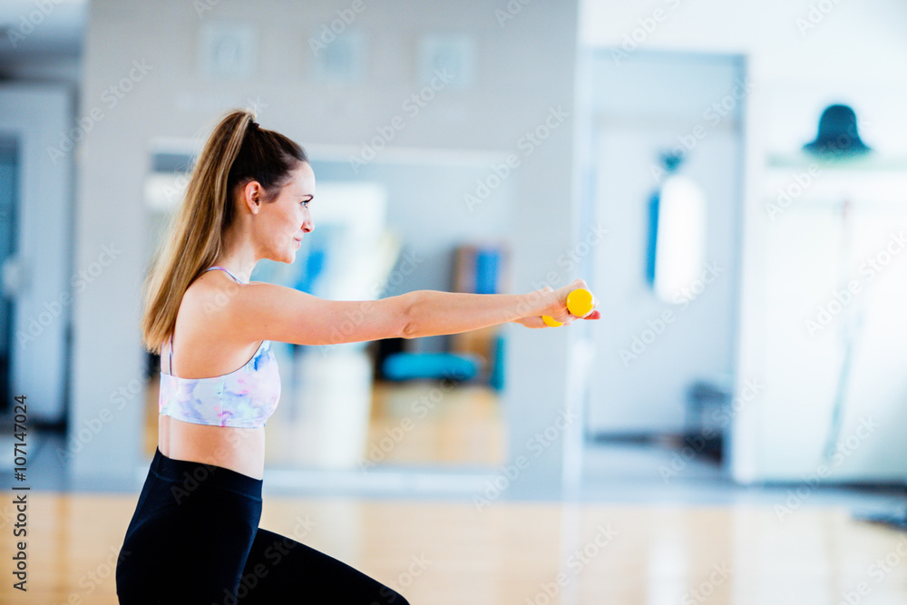 Brunette woman exercising with light weights