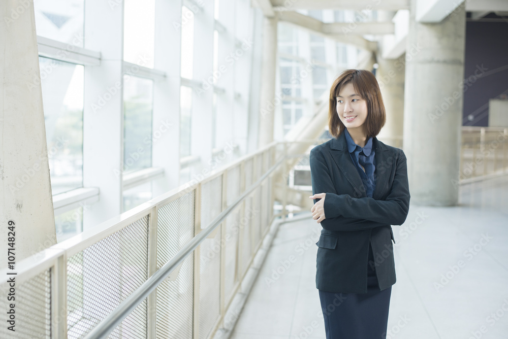 Attractive asian business woman smiling outside office Attractive asian business woman smiling outside office