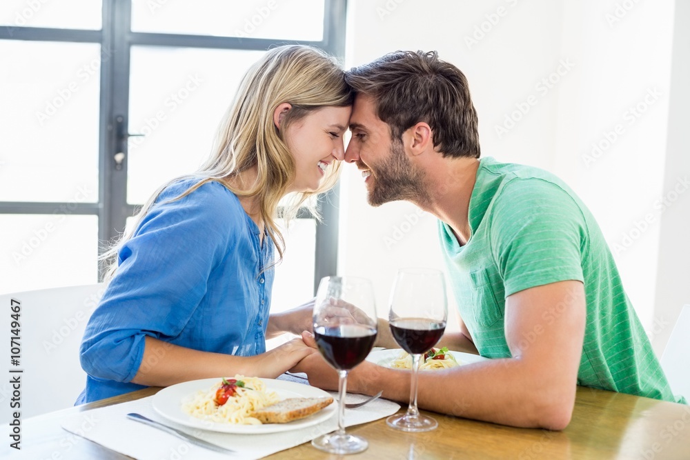 Young couple sitting face to face at dinning table Young couple sitting face to face at dinning table