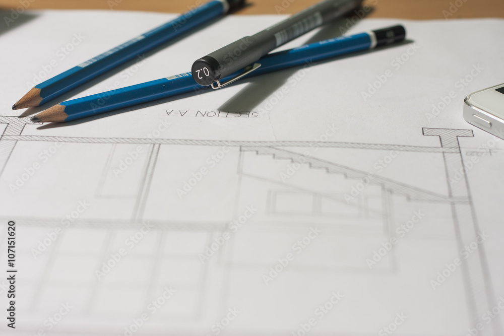 Architectural blueprints and blueprint rolls and a drawing instruments on architects desk Architectural blueprints and blueprint rolls and a drawing instruments on architects desk
