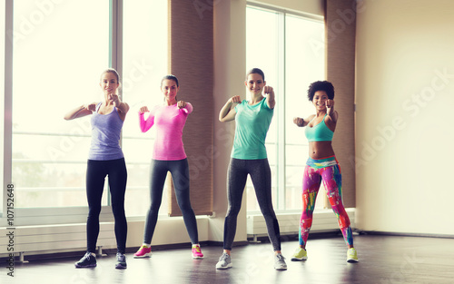group of happy women working out in gym
