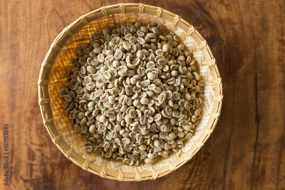 green coffee beans in wooden basket on Wood table green coffee beans in wooden basket on Wood table