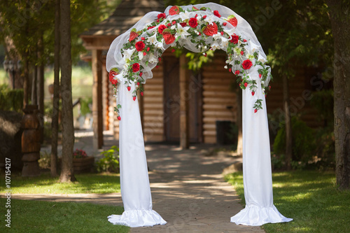 stylish wedding arch with red roses and white lilies, garden, we