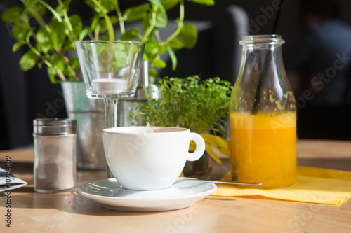 Bottle of Freshly squeezed orange juice sitting on a rustic wooden table.