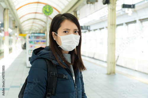 Woman wearing face mask in train station