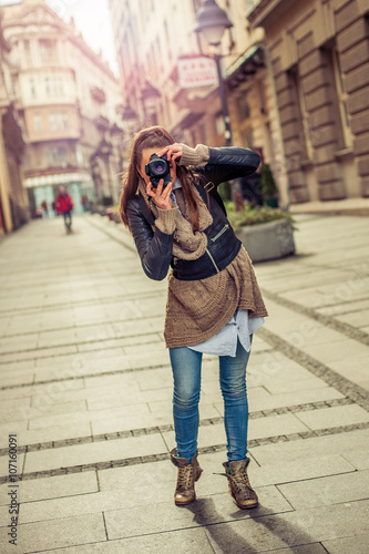 Pretty young female tourist photographer taking pictures in the city © guruXOX