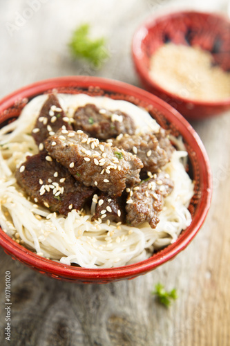 Fried beef with noodles and sesame seeds