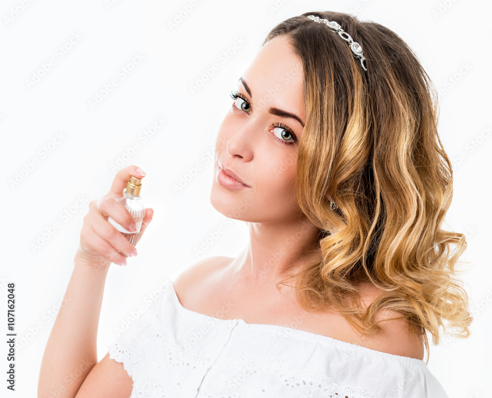 Portrait of a beautiful young woman with bottle of perfume