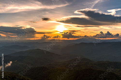 View of forest and mountain landscape at sunset.