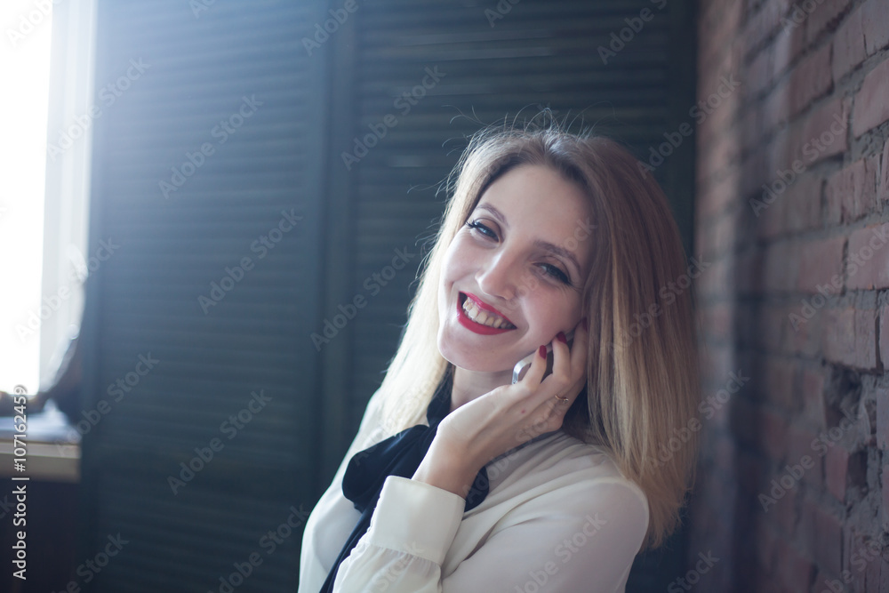 Fototapeta premium Portrait of a beautiful girl talking on the phone
