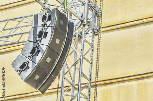 Concert sound system on metal structures at height outdoor with old building in background.Selective focus.