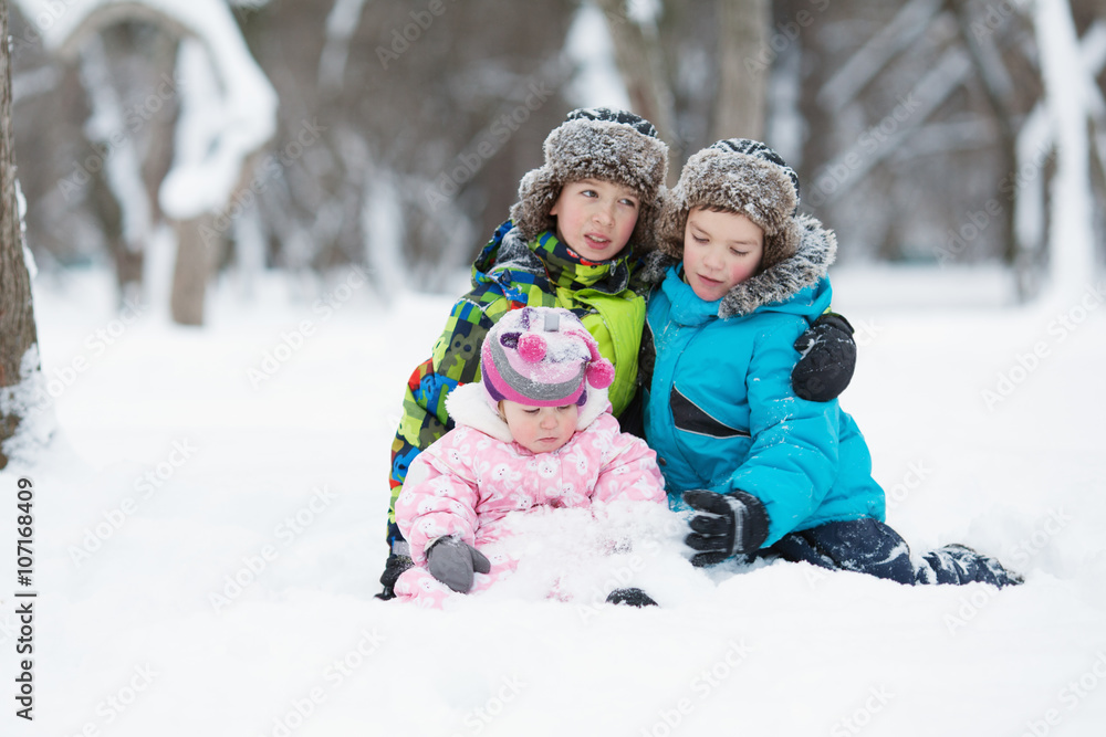 Portrait of Two cheerful happy boys and baby girl in winter park