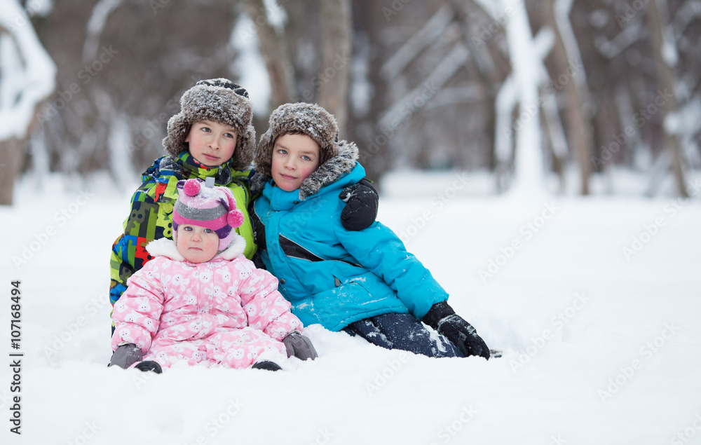 Portrait of Two cheerful happy boys and baby girl in winter park
