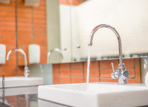 Bathroom interior with white sink and metal faucet