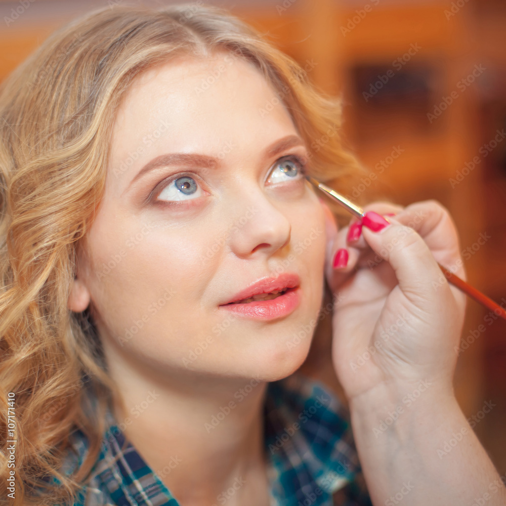 make up artist doing professional make up of young woman make up artist doing professional make up of young woman