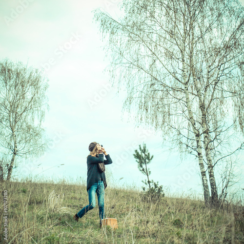 Hipster girl walks in the morning and photographs on vintage camera outdoors © ruslimonchyk