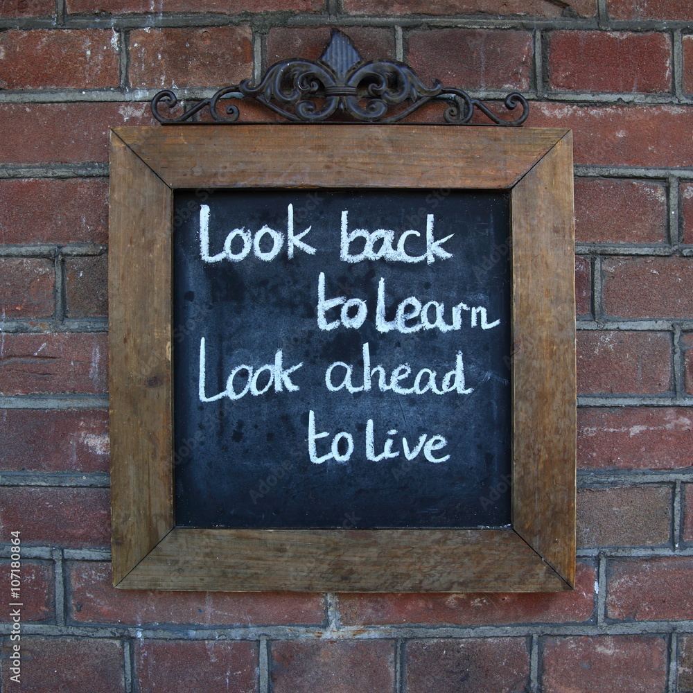 learning and living/ saying written on a chalk board learning and living/ saying written on a chalk board