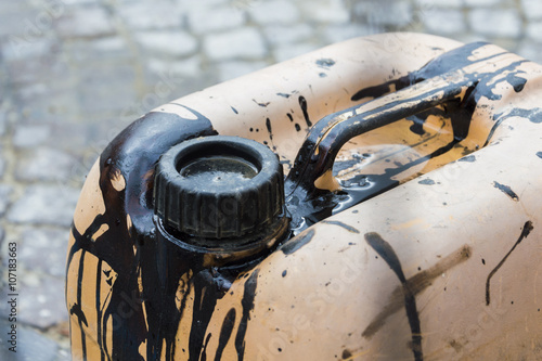 Focus on old jerry can dirty of black petrol