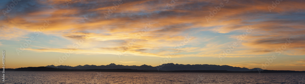 Olympic Mountains Panorama. Panoramic view of the Olympic Mountain range seen from the Seattle waterfront during a dramatic springtime sunset.