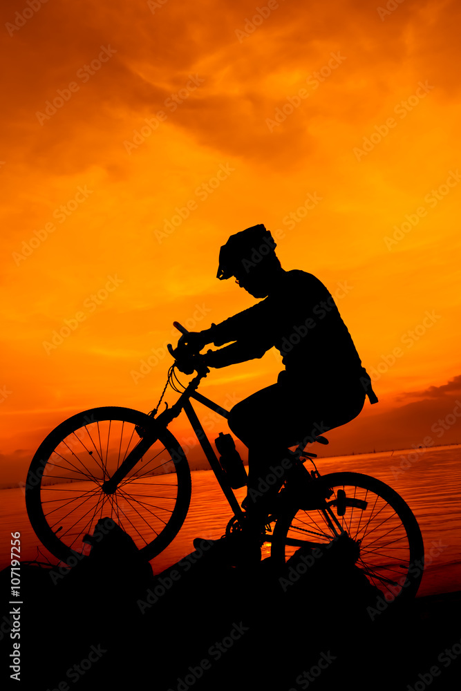 Obraz premium Healthy lifestyle. Silhouette of bicyclist riding the bike at seaside.