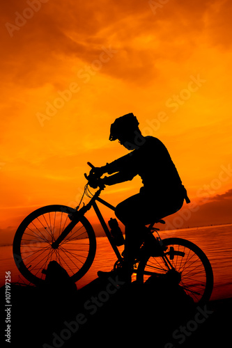 Fototapeta Naklejka Na Ścianę i Meble -  Healthy lifestyle. Silhouette of bicyclist riding the bike at seaside.