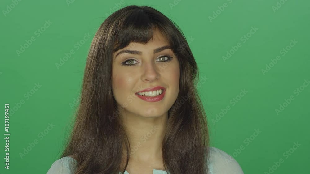 Beautiful brunette woman smiling, on a green screen studio background Beautiful brunette woman smiling, on a green screen studio background
