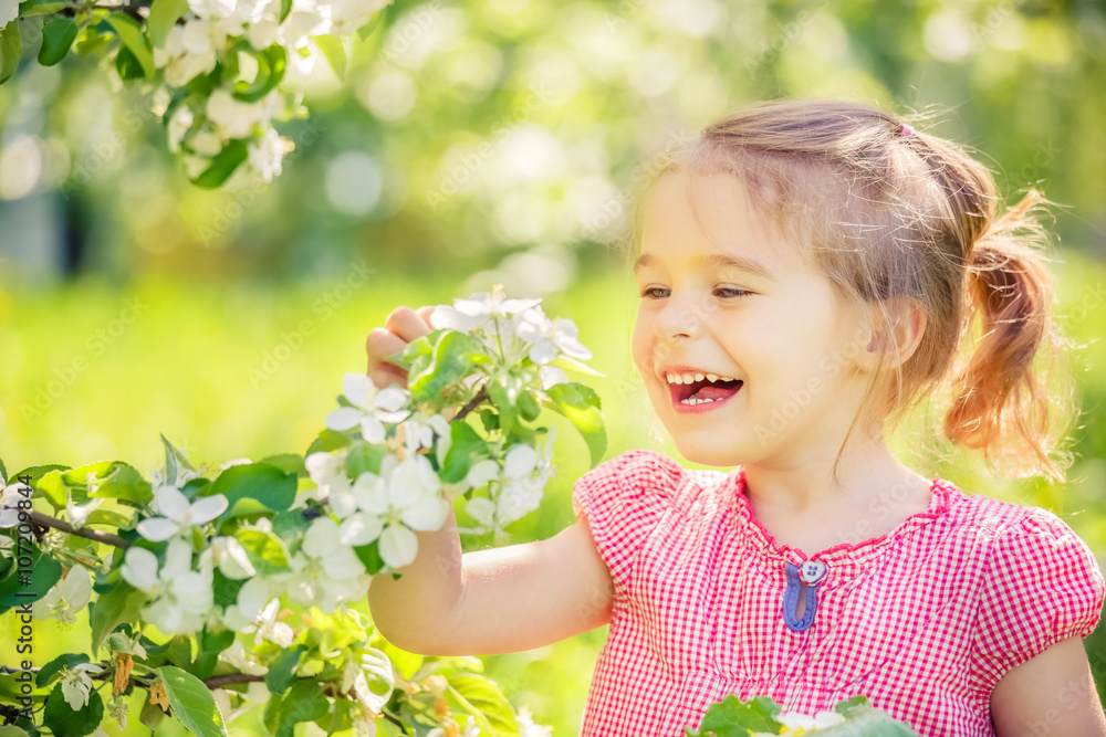Happy little girl playing in spring apple tree garden Happy little girl playing in spring apple tree garden