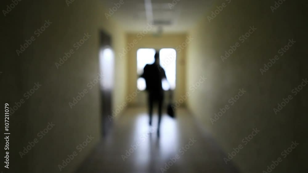 The silhouette of a man goes through the dark corridor to a bright future. The Ghost of a businessman .The path to success. The silhouette of a man goes through the dark corridor to a bright future. The Ghost of a businessman .The path to success.