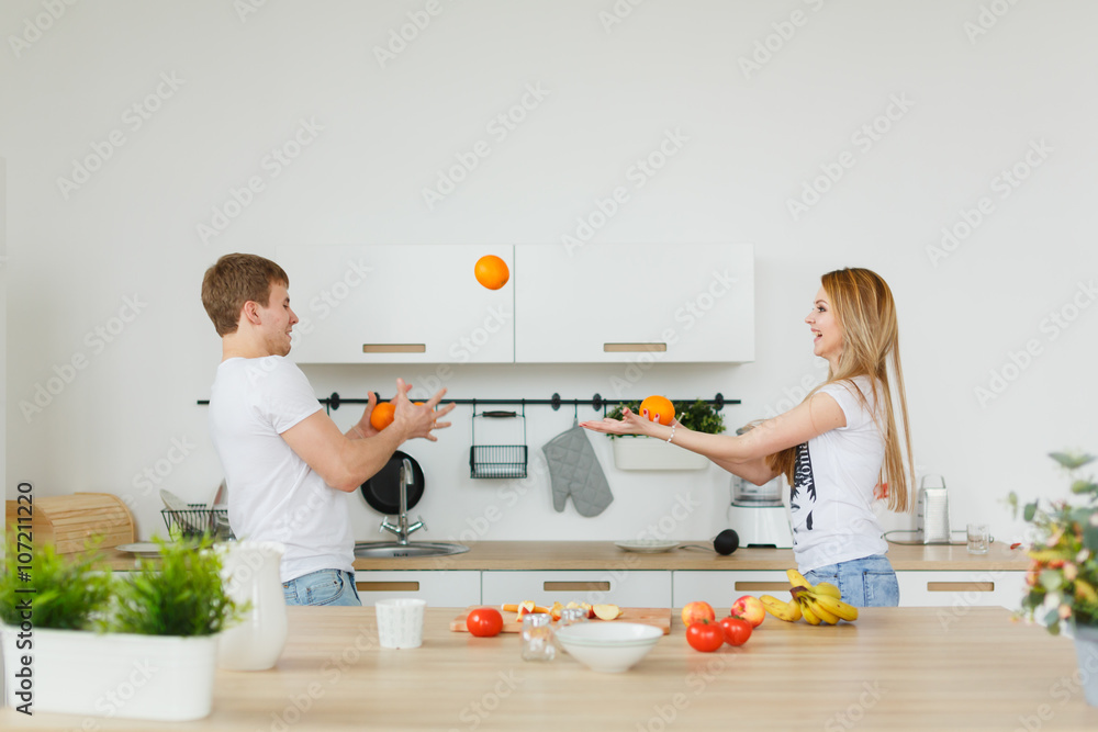 Young couple cooking - man and woman in their kitchen Young couple cooking - man and woman in their kitchen