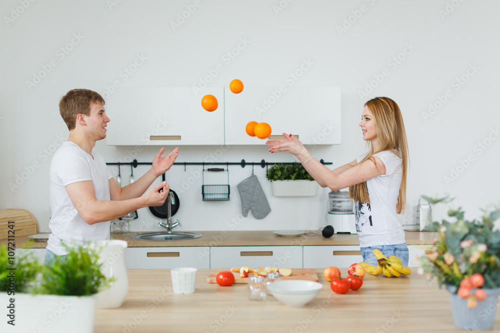 Young couple cooking - man and woman in their kitchen