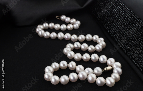 Pearl necklace on black jacket