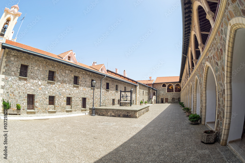 Fisheye view on ancient Kykkos Monastery (1081) court with stonemason buildings and arched passage. Cyprus.
