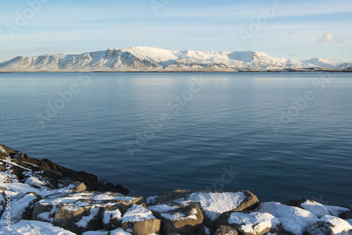 Seafront at Reykjavik at sunny winter day, city landscape with mountains, Iceland