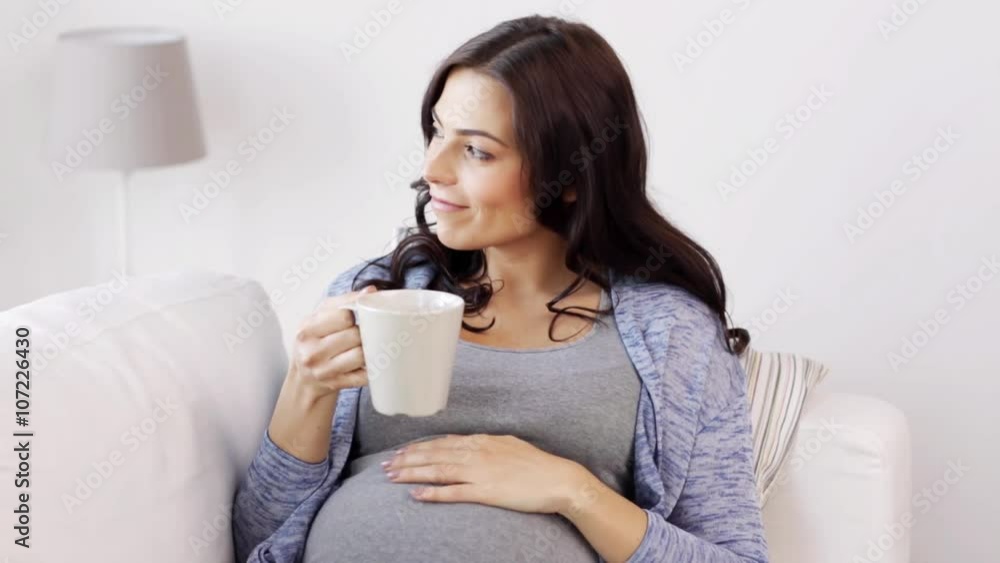happy pregnant woman with cup drinking tea at home happy pregnant woman with cup drinking tea at home