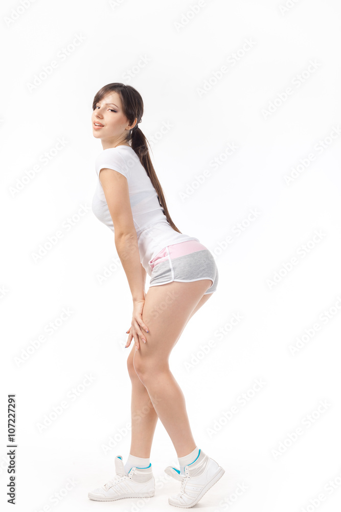 Young woman doing squatting exercise isolated on white background Young woman doing squatting exercise isolated on white background