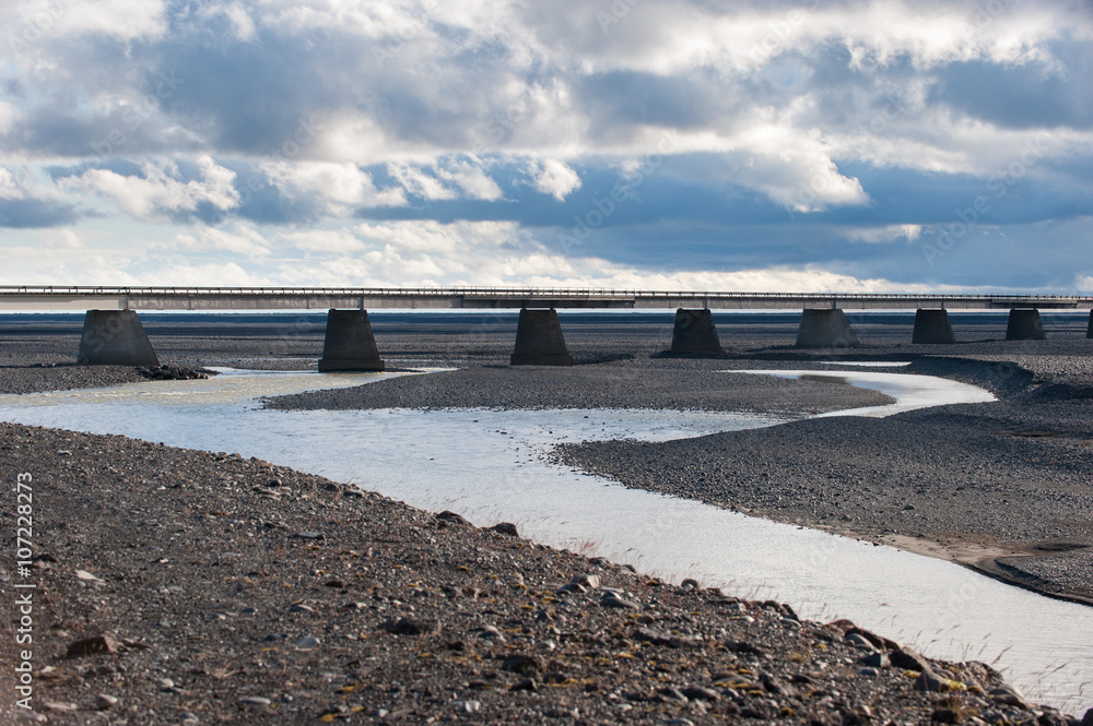 Single bridge in the landscape with stormy sky, Iceland