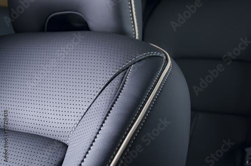 Part of  leather car seat with the unfocused car interior on the background