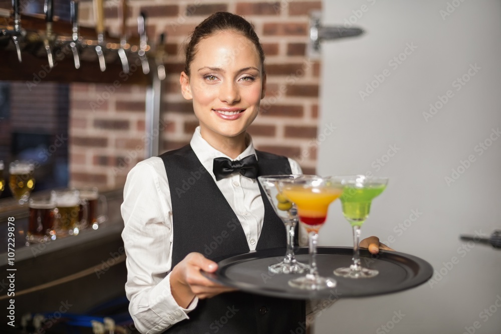 Barmaid holding plate with cocktails