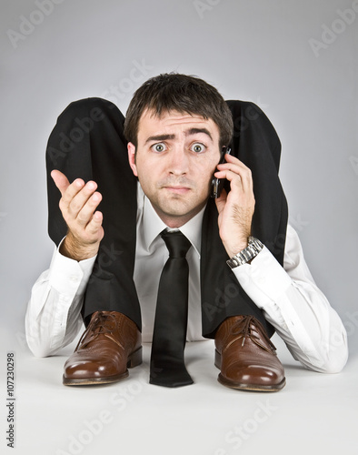 Foto flexible businessman with doubtful face talking on the phone isolated on white