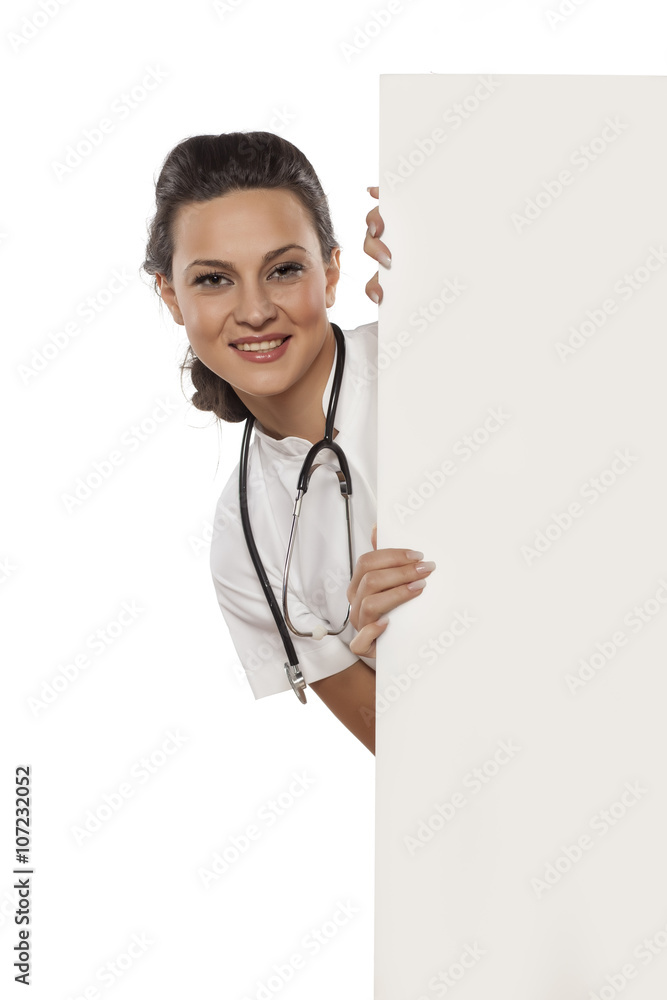 a young woman doctor peek behind the white blank board
