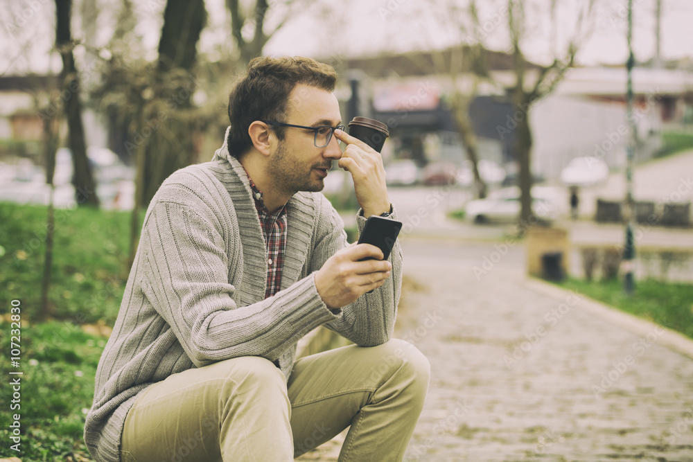 Hipster modern guy using a smartphone.
Hipster modern guy using a smartphone.