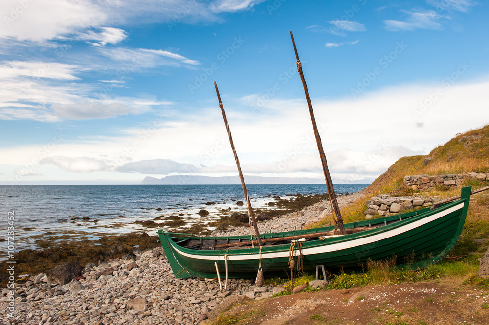 Old fishing boat, boat of the Vikings on the ocean shore, Iceland Old fishing boat, boat of the Vikings on the ocean shore, Iceland