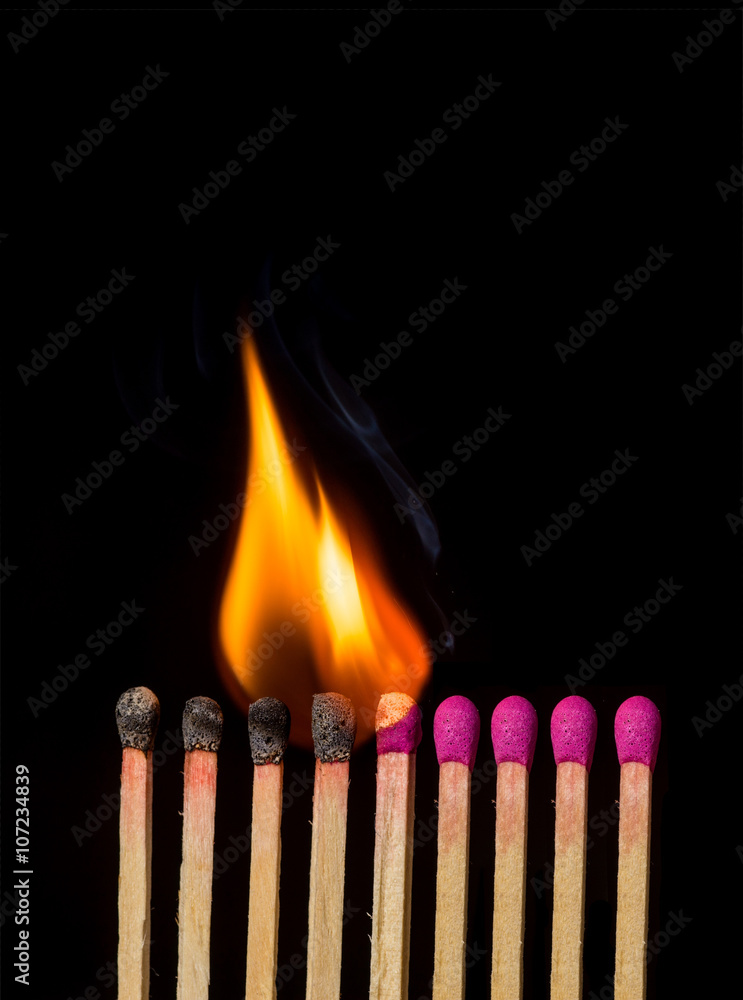 Line of lighted matches on black background Line of lighted matches on black background