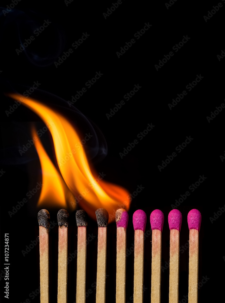 Line of lighted matches on black background Line of lighted matches on black background
