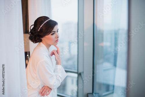 Portrait of a beautiful young girl in a white robe in the bedroom near the window, morning, boudoir, relaxation, evening Free Download Portrait of a beautiful young girl in a white robe in the bedroom near the window, morning, boudoir, relaxation, evening - GFXLoad