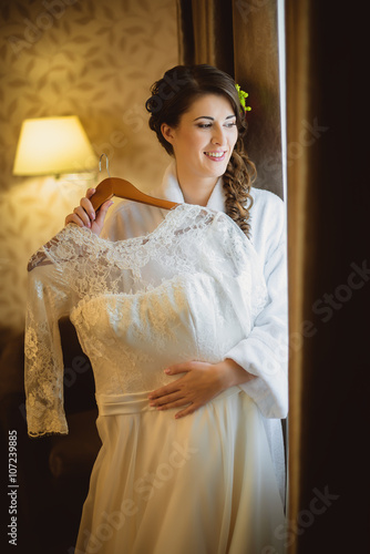 Bride holding wedding dress