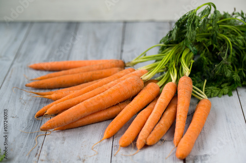 Fresh carrots bunch on wooden background