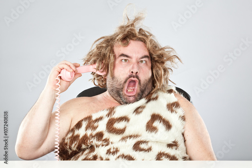 Billede på lærred ugly rude prehistoric man with phone in his hair